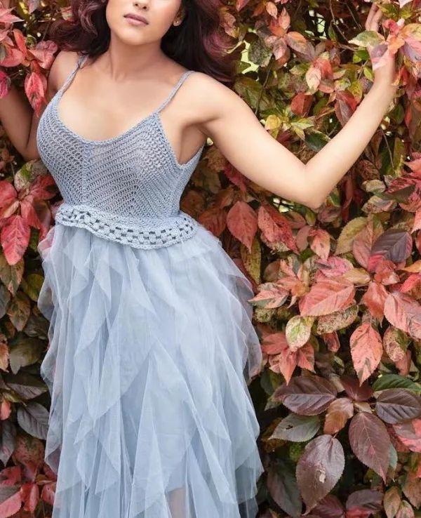 Indian escort Ananya standing by a flower wall 