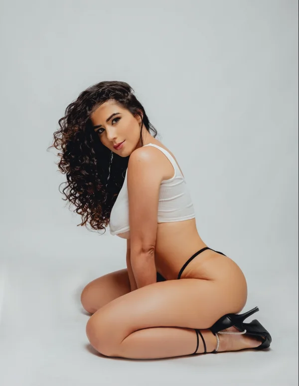 Curvy London escort Brooklyn is wearing a black thong and a white crop top 