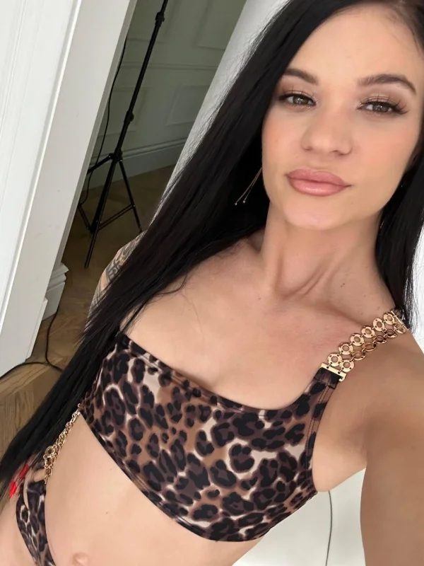 A selfie of brunette escort Carina in a leopard print top 