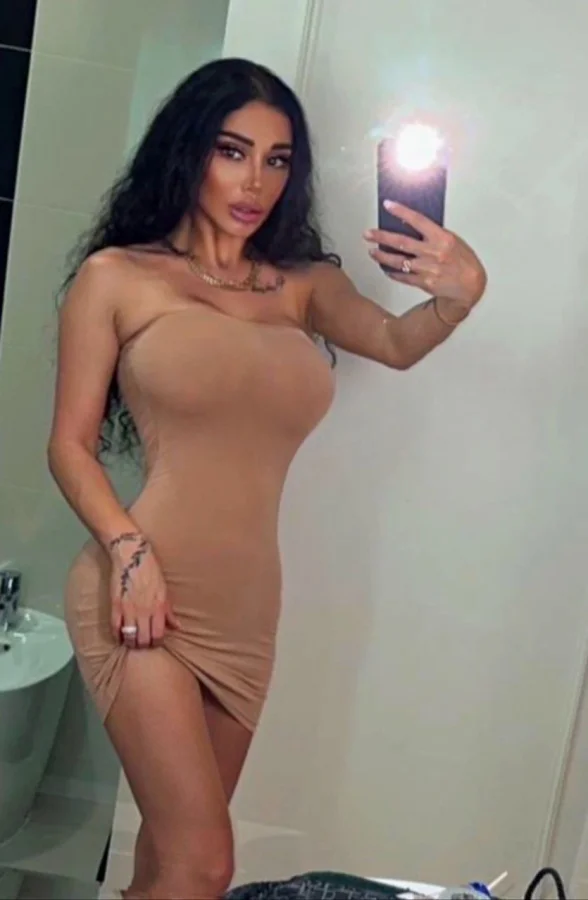 Busty brunette escort from Russian pictured in a very sexy beige dress 