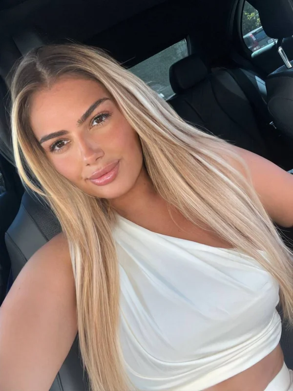 Blonde London escort wearing a white top 
