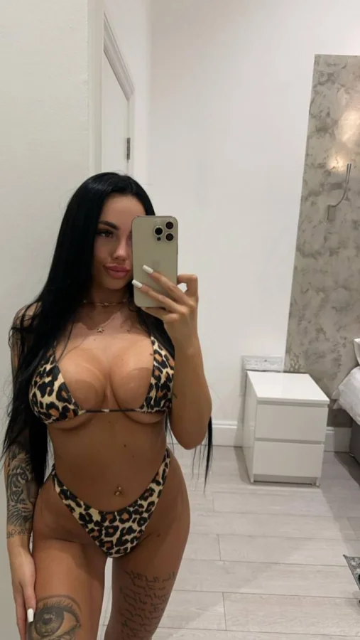 Busty London escort Karson  is wearing a leopard print bikini in this photo 