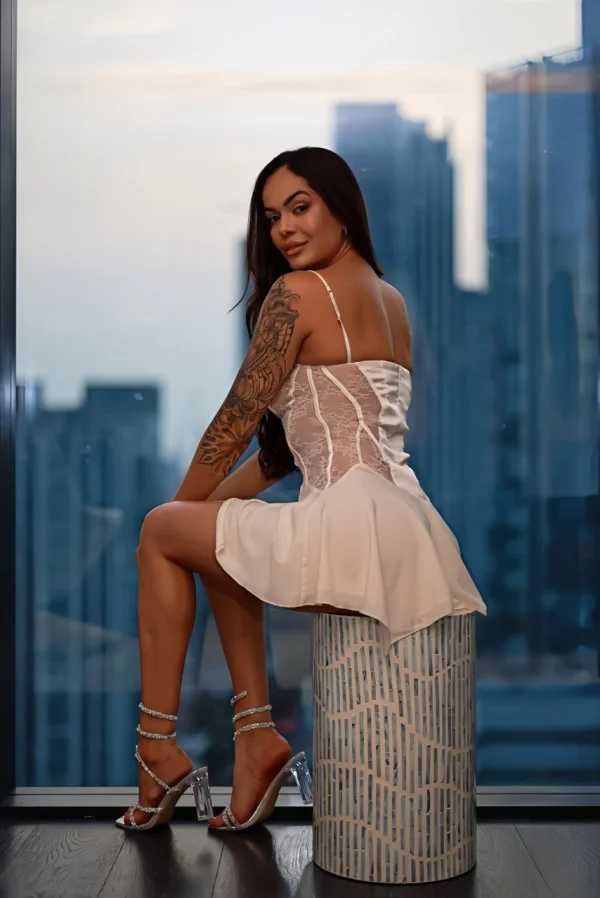 Sexy escort lady wearing a white dress and shes showing off her sleeve tattoo 