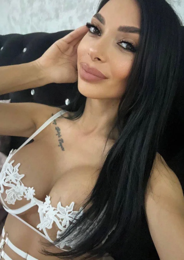 A London escort with big boobs wearing a white bra 