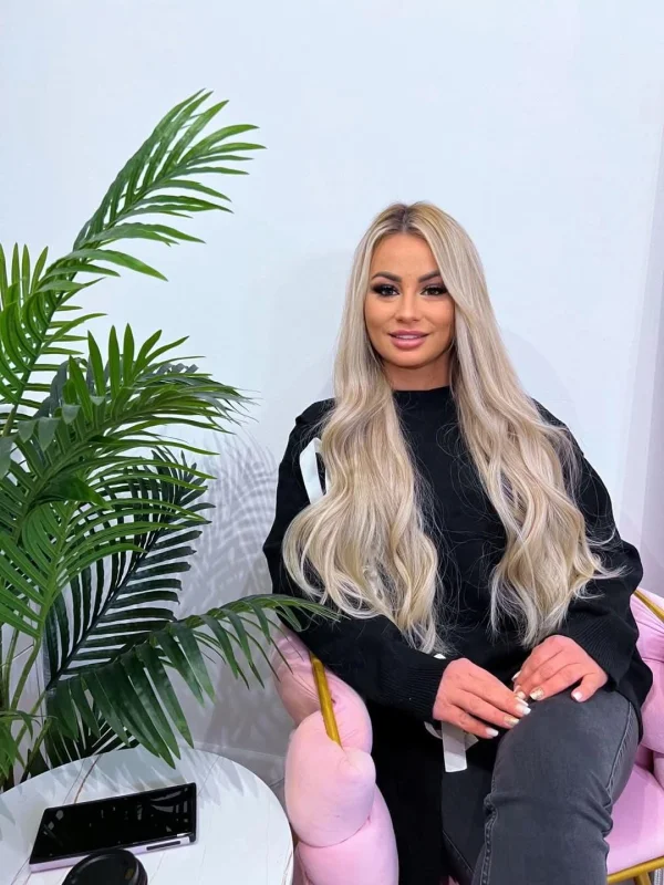 A selfie of a blonde escort sitting in a chair 