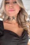 A selfie of a sexy London escort showing off her neck tattoo 
