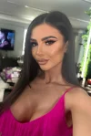 Brunette escort Kaisa is wearing a pink vest top in this picture 